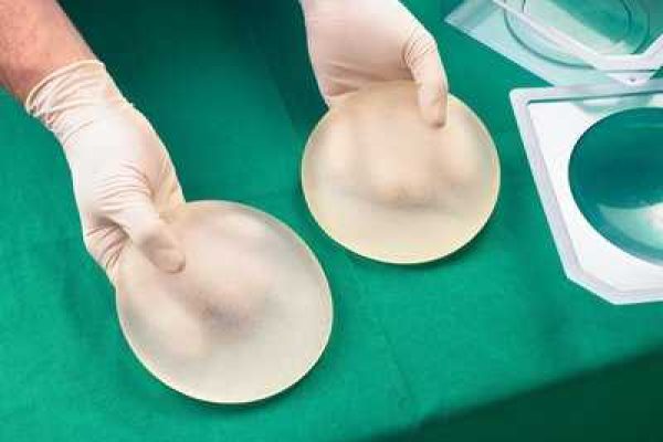 Surgeon holding silicone breast implants, close-up, elevated view