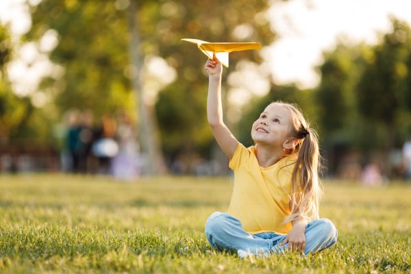 cute-little-girl-with-paper-plane-outdoor
