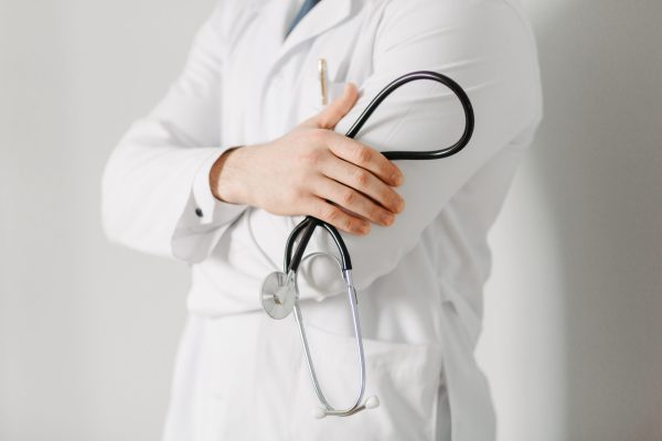 Portrait of a friendly doctor. Isolated on gray
