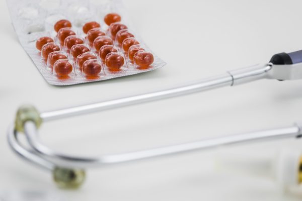 red-pill-blister-pack-with-stethoscope-white-background